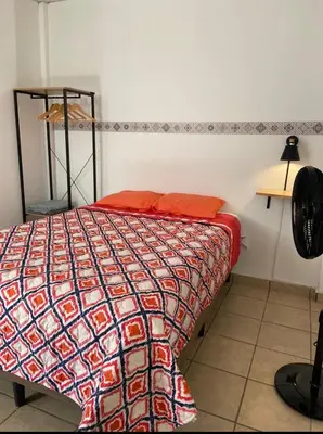 a bedroom with a bed with a colorful comforter at Terrazas Guest House-Hostal in Suchitoto