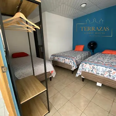 a room with two beds and a sign on the wall at Terrazas Guest House-Hostal in Suchitoto