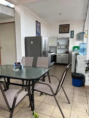 a kitchen with a table and chairs and a refrigerator at Terrazas Guest House-Hostal in Suchitoto