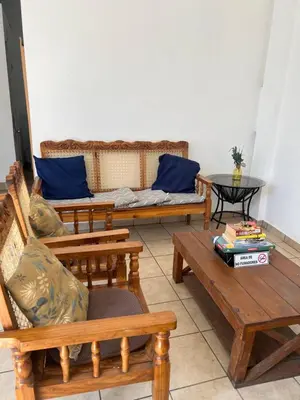 a living room with wooden benches and a couch at Terrazas Guest House-Hostal in Suchitoto