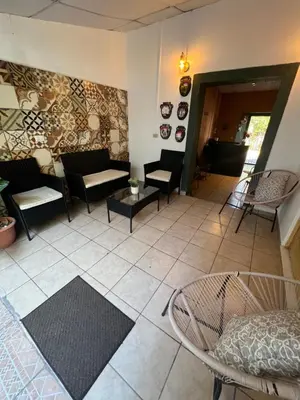 a living room with couches and tables and chairs at Terrazas Guest House-Hostal in Suchitoto