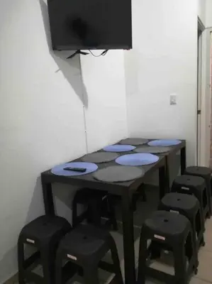 a table with stools and a tv on a wall at Tiny but cozy home in Santa Ana in Santa Ana