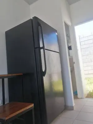 a black refrigerator in a kitchen with a table at Tiny but cozy home in Santa Ana in Santa Ana