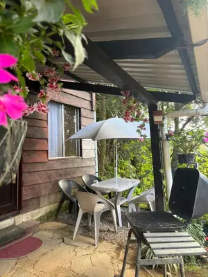 a patio with a table and chairs and an umbrella at Cabaña privada en Los Naranjos in Los Naranjos