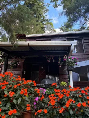 a house with a bunch of flowers in front of it at Cabaña privada en Los Naranjos in Los Naranjos