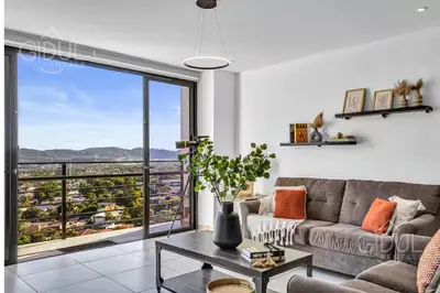 a living room with a couch and a large window at Modern apt with stunning city and mountain views in San Salvador