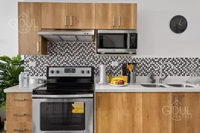 a kitchen with a stove and a microwave at Modern apt with stunning city and mountain views in San Salvador