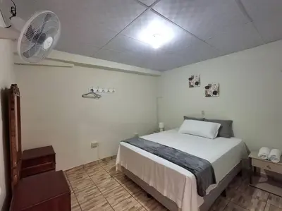 a bedroom with a large bed and a fan at Casa Centro Histórico Santa Ana in Santa Ana