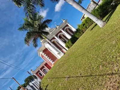 a large building with a palm tree in front of it at Casa Centro Histórico Santa Ana in Santa Ana