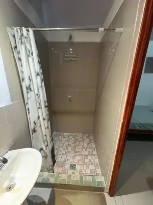 a bathroom with a shower and a sink at Hostal Sunset Town in Ahuachapán