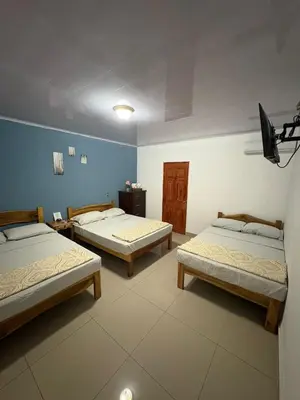 three beds in a room with blue walls at Hostal Sunset Town in Ahuachapán