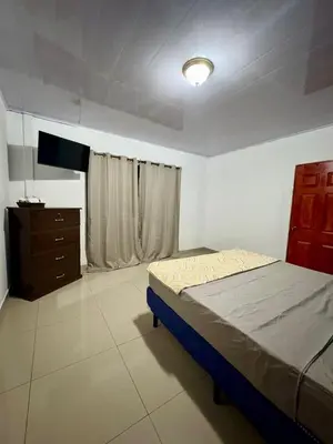 a bedroom with a bed and a dresser in it at Hostal Sunset Town in Ahuachapán