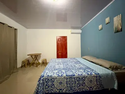 a bedroom with a bed and a blue wall at Hostal Sunset Town in Ahuachapán