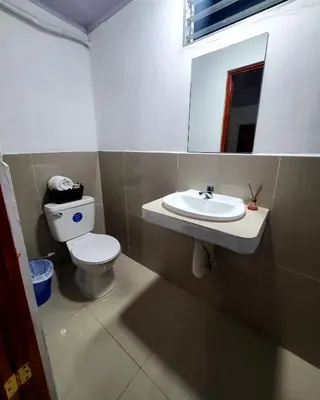 a bathroom with a toilet and a sink at Hostal Sunset Town in Ahuachapán