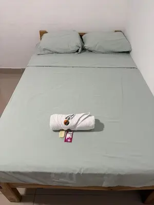 a bed with a towel sitting on top of it at Hostal Sunset Town in Ahuachapán