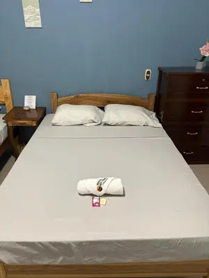 a bedroom with a bed with a towel on it at Hostal Sunset Town in Ahuachapán