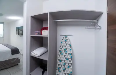 a room with a bed and a closet with a tie at Condo 9, San Francisco Tower in San Salvador