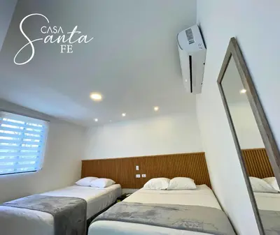 a room with two beds and a mirror at Casa Santa Fe in San Salvador
