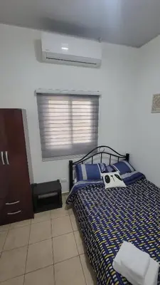 a bedroom with a bed with a black and blue at Toto's House, near Mall Las Ramblas in Santa Ana