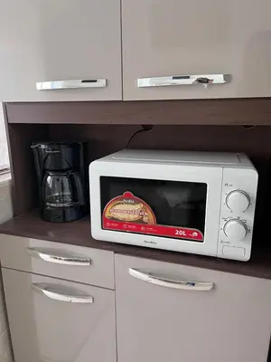 a microwave sitting on a kitchen counter next to a coffee maker at Toto's House, near Mall Las Ramblas in Santa Ana