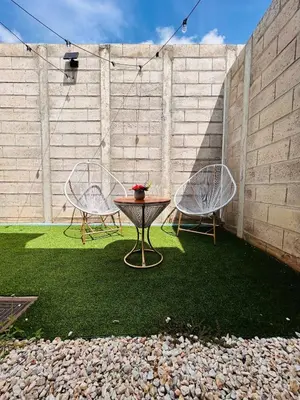 a patio with two chairs and a table on grass at Toto's House, near Mall Las Ramblas in Santa Ana