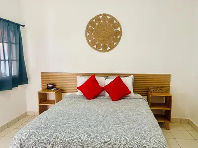 a bedroom with a bed with two red pillows at The Beach Break Hotel El Cocal in Playa San Blas