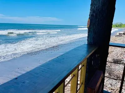 a view of the beach from a wooden balcony at The Beach Break Hotel El Cocal in Playa San Blas