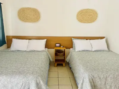 two beds sitting next to each other in a room at The Beach Break Hotel El Cocal in Playa San Blas