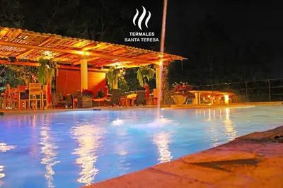 a swimming pool at a resort at night at Casa Ruta Termal - Ahuachapan in Ahuachapán