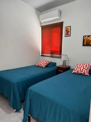 two beds in a room with blue sheets and a window at Tu Hogar Encantado Casa Entera con dos Habitaciones in San Miguel