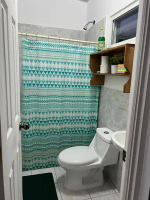 a bathroom with a toilet and a shower at Tu Hogar Encantado Casa Entera con dos Habitaciones in San Miguel