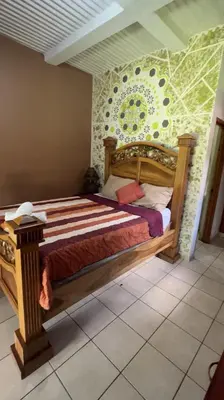 a bedroom with a wooden bed with a wall at 1961 Los Naranjos Hostal in Los Naranjos