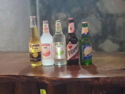 four bottles of beer sitting on a wooden table at Restaurante y Hostal Romayor in Hacienda Santa Rosa