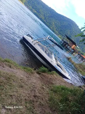 a boat parked on the side of a river at Restaurante y Hostal Romayor in Hacienda Santa Rosa