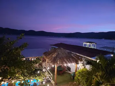 a house with a view of the water at night at Restaurante y Hostal Romayor in Hacienda Santa Rosa