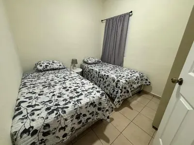 a bedroom with two beds and a window at La Casita de Vacaciones in San Miguel