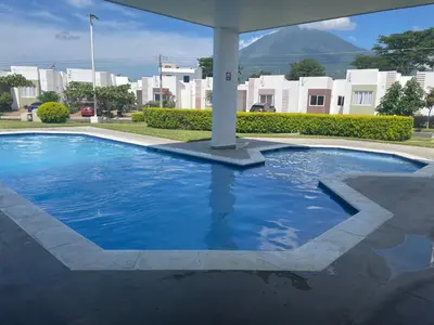 a large blue pool with buildings in the background at La Casita de Vacaciones in San Miguel