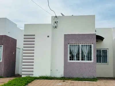 a white and purple building with a window at La Casita de Vacaciones in San Miguel