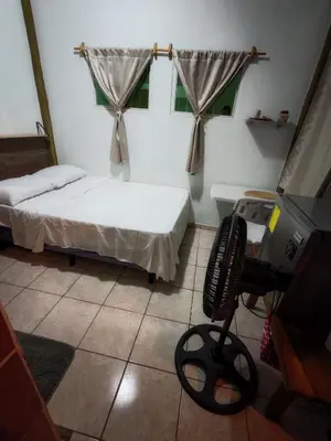a small room with a bed and a television at Casa de Limón 01 in Santa Ana