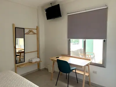 a bedroom with a desk and a bed and a mirror at Hotel Rimani in San Salvador