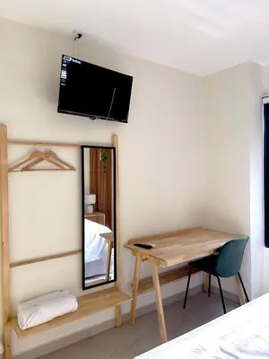 a room with a table and a mirror and a television at Hotel Rimani in San Salvador