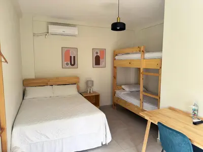 a bedroom with two bunk beds and a desk at Hotel Rimani in San Salvador