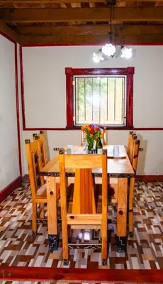 a dining room with a wooden table and chairs at Lacasadelbosquesv in Río Chiquito