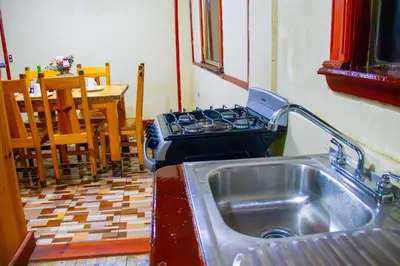 a kitchen with a stove and a stainless steel sink at Lacasadelbosquesv in Río Chiquito