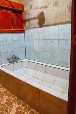 a tub in a kitchen with blue tiles at Lacasadelbosquesv in Río Chiquito