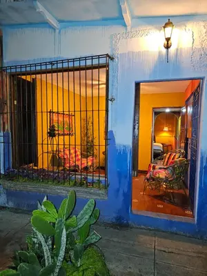 a blue building with a gate with chairs in a room at Santa Fe in Juayúa
