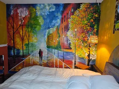 a bedroom with a painting of a man walking down a street at Santa Fe in Juayúa