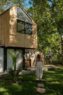 a woman walking in front of a house at Unique Tiny House-Best Beach in El Zonte in El Zonte