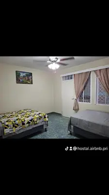 a bedroom with two beds and a ceiling fan at Hostal Primaveras nest habitación 3 in Santa Ana