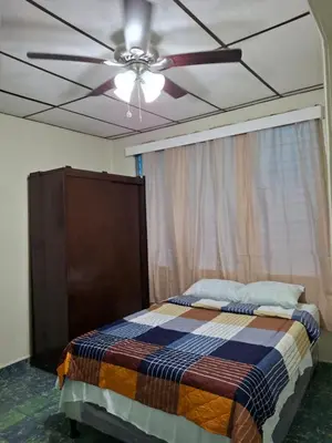 a bedroom with a ceiling fan and a bed at Hostal primaveras nest in Santa Ana